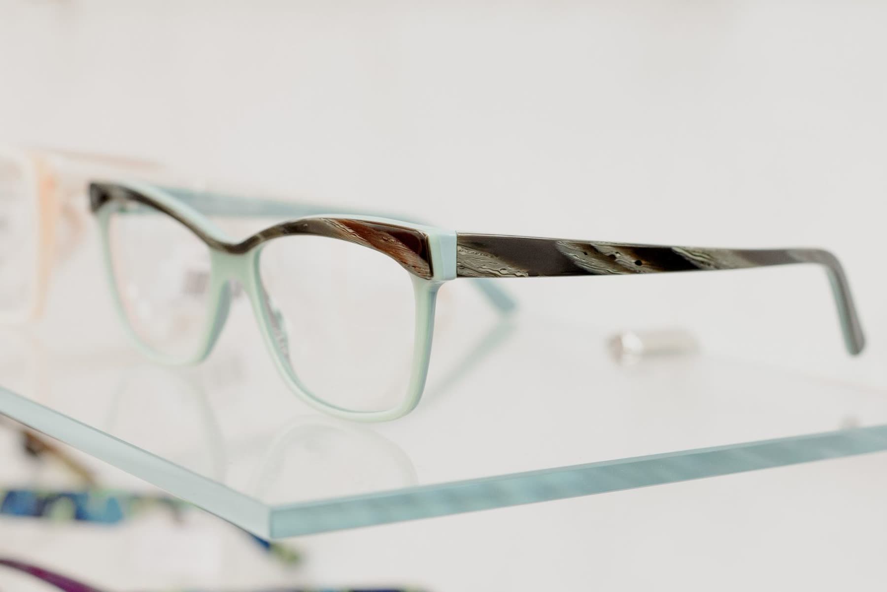 Designer eyeglasses arranged on a warm surface